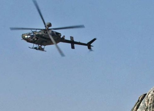 First Lt. Peter Cacossa directs an OH-58 Kiowa helicopter from a rooftop toward the sound of small-arms fire heard during a raid in Mosul, Iraq, April 17, 2008. 