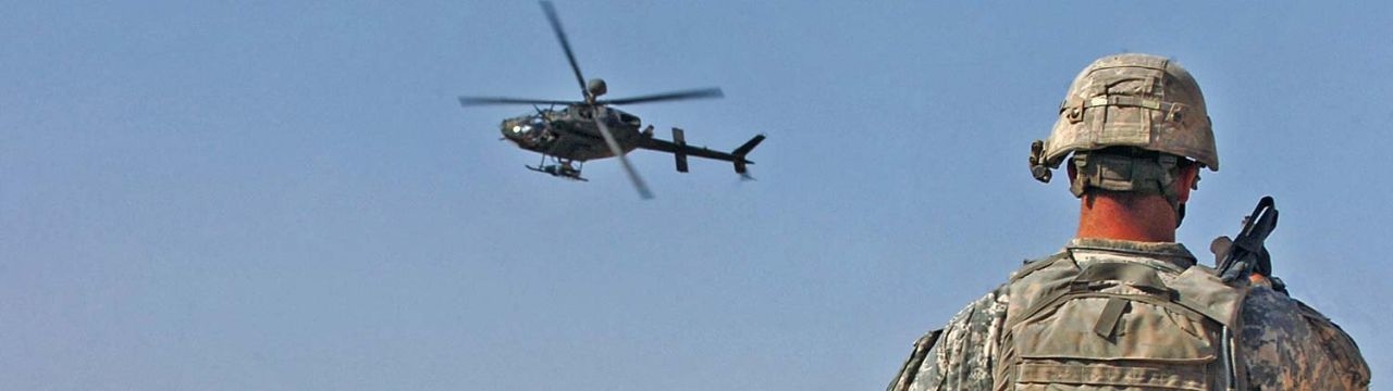 First Lt. Peter Cacossa directs an OH-58 Kiowa helicopter from a rooftop toward the sound of small-arms fire heard during a raid in Mosul, Iraq, April 17, 2008. 