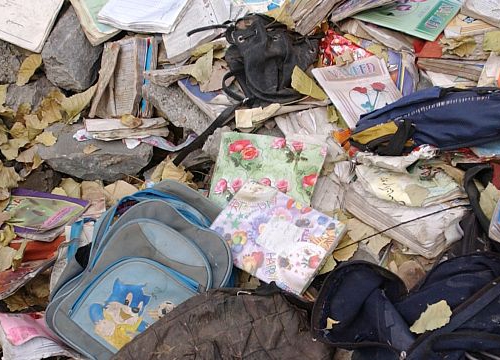 Children's clothes scattered amongst the debris of a collapsed building