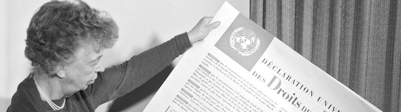 November 1949, Eleanor Roosevelt of the United States holding a Universal Declaration of Human Rights poster in French. 