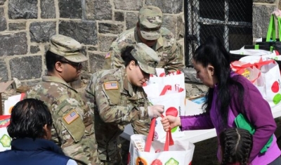 New York National Guard Soldiers from the 101st Signal Battalion hand groceries to members of the community at a food distribution point at Hope Community Services in New Rochelle on March 18, 2020.