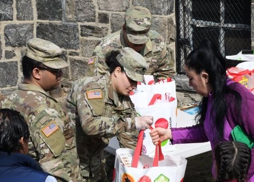 New York National Guard Soldiers from the 101st Signal Battalion hand groceries to members of the community at a food distribution point at Hope Community Services in New Rochelle on March 18, 2020.