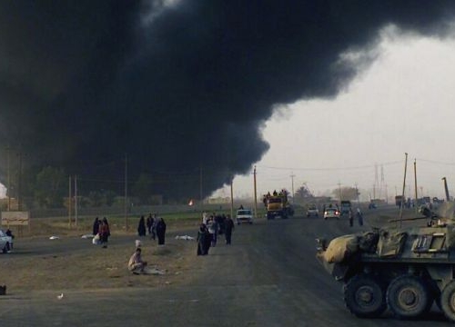 Smoke from a burning oil field rises into the air, Iraq, 2006