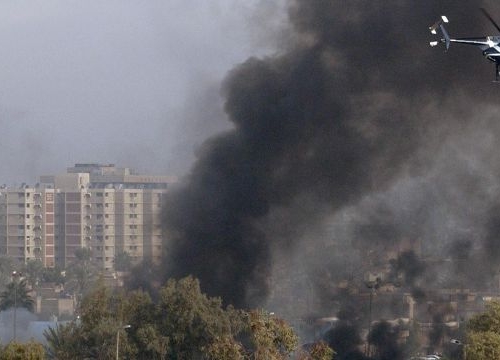 A Blackwater Security Company MD-530F helicopter aids in securing the site of a car bomb explosion in Baghdad, Iraq, on December 4, 2004, during Operation IRAQI FREEDOM