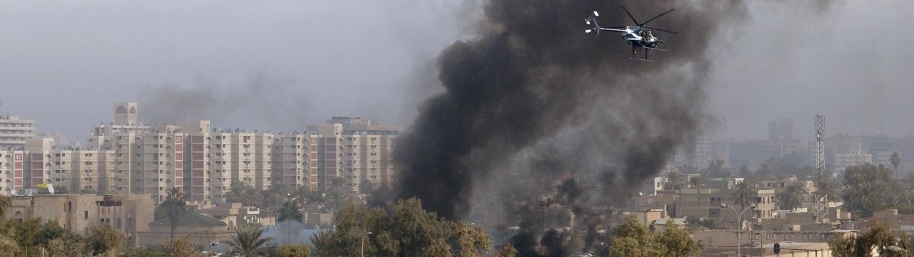 A Blackwater Security Company MD-530F helicopter aids in securing the site of a car bomb explosion in Baghdad, Iraq, on December 4, 2004, during Operation IRAQI FREEDOM