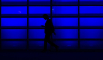 Persons walking in front of a blue wall