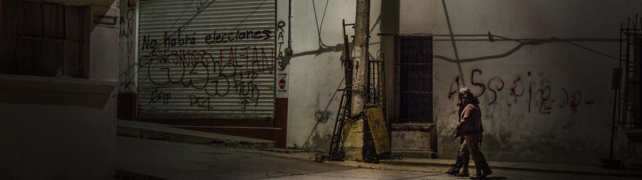 Mexico, two persons walk in th street at night