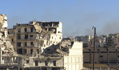 Aleppo. Buses await to enter Eastern Aleppo to evacuate civilians while sporadic fighting continues and houses are burning.