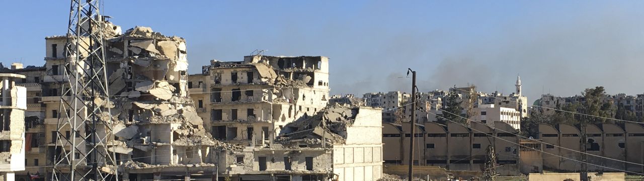 Aleppo. Buses await to enter Eastern Aleppo to evacuate civilians while sporadic fighting continues and houses are burning.