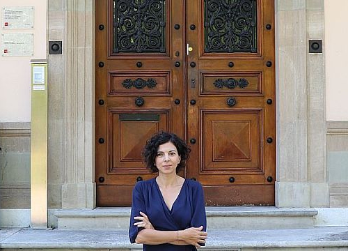 Nadia Oulaby in front of the entrance of Villa Moynier, the Geneva Academy Headquarters