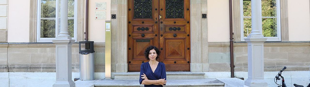 Nadia Oulaby in front of the entrance of Villa Moynier, the Geneva Academy Headquarters