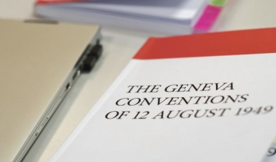 A labtop and the book of the 1949 Geneva Conventions