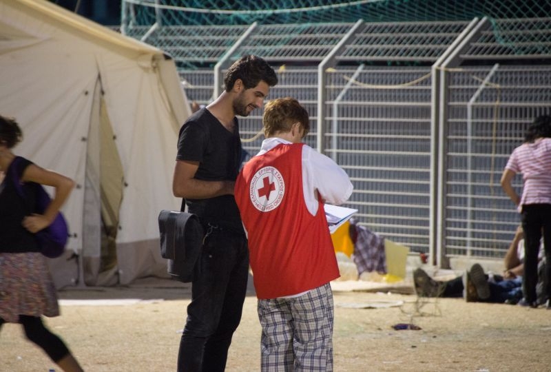 Greece, Lesbos. 2015. Ahmed Selo gets help from Hellenic Red Cross volunteer Katerina.