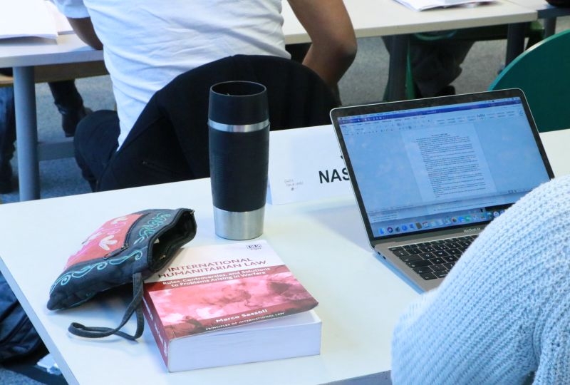 A student's desk during a LLM class on IHL