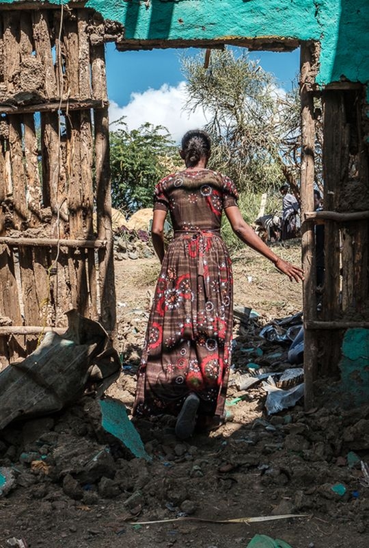 Consequence of the conflict in Tigray (woman walking out of a destroyed house