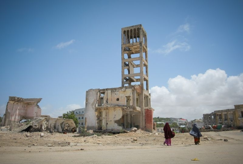 Two women walk past bombed-out and destroyed buildings in the Boondheere district of the Somali capital Mogadishu