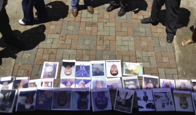 Tegucigalpa, Central Park. Pedestrians are looking at portraits of missing persons, during the International Day of Missing Persons. 