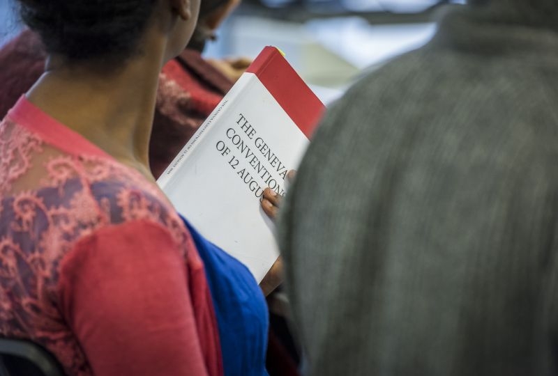 A Greneva Academy student holds the Geneva Conventions during a class