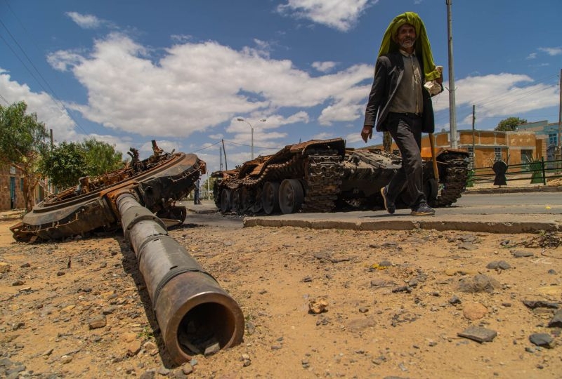 A man passes by a destroyed tank on the main street of Edaga Hamus, in the Tigray region, in Ethiopia, on June 5, 2021