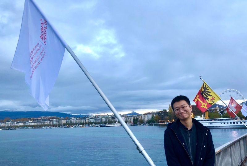 Tong Li on the Mont-Blanc Bridge with the Geneva Academy flags