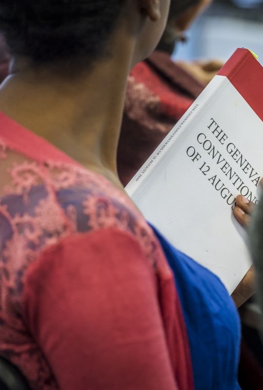 A student during a Geneva Academy cours, holding the Geneva Conventions