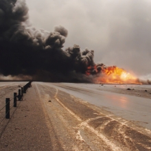 Road through oil well burning in field with oil slick, Kuwait